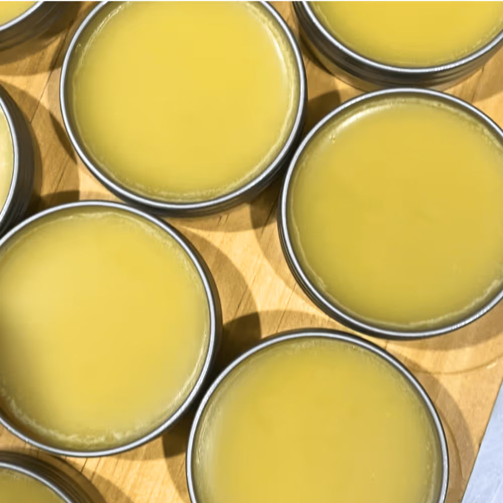 Open tins of golden CBD topical balm