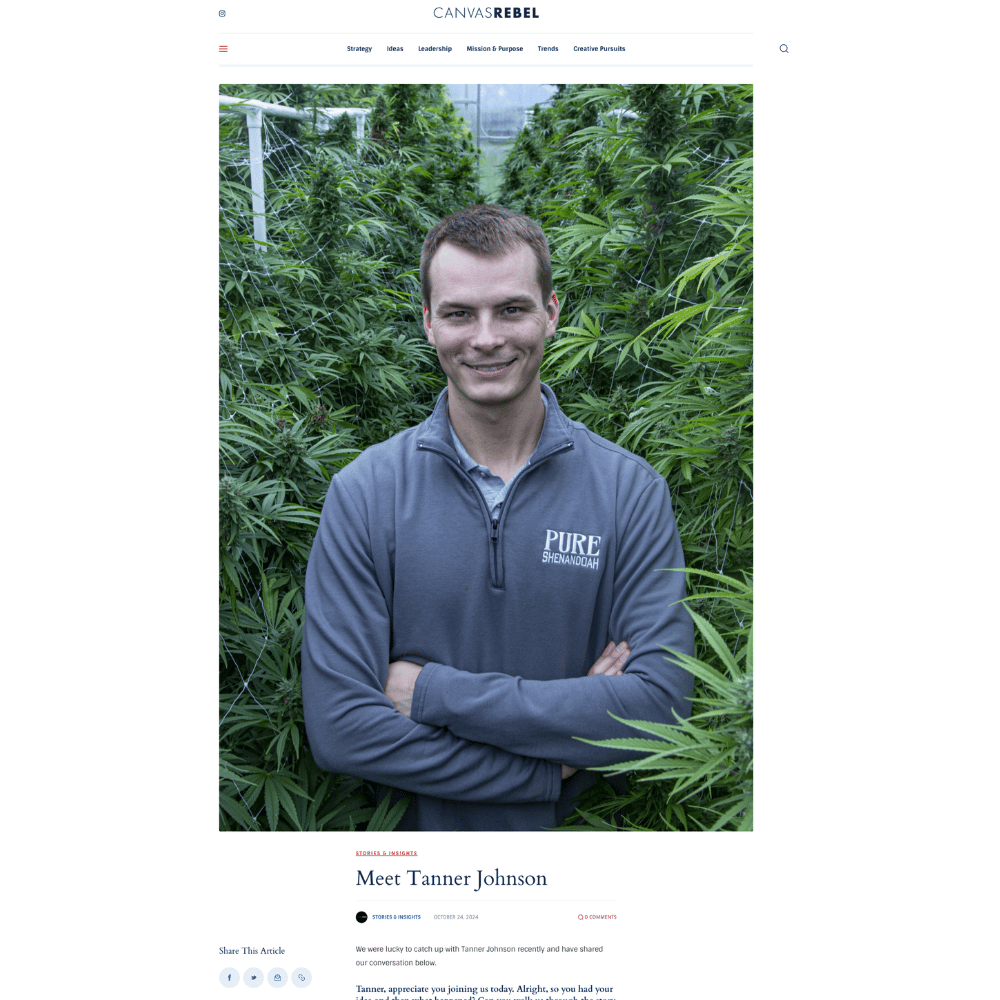 Tanner Johnson standing with folded arms inside a cannabis greenhouse
