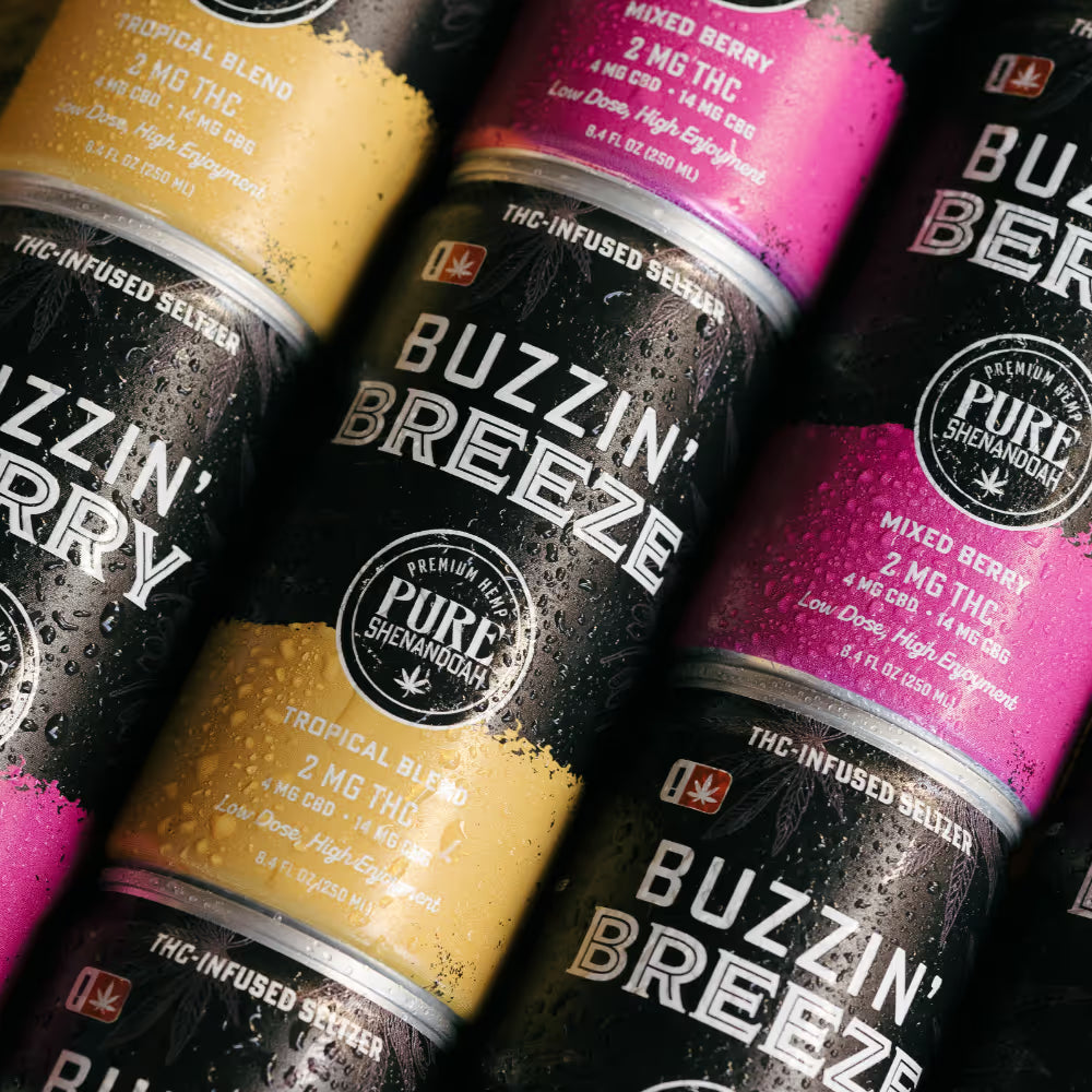 Assortment of Buzzin THC seltzer cans in pink orange and yellow