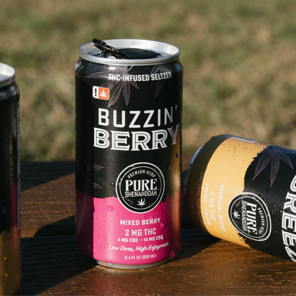 Buzzin Berry and Buzzin Breeze THC seltzer cans on a wooden table
