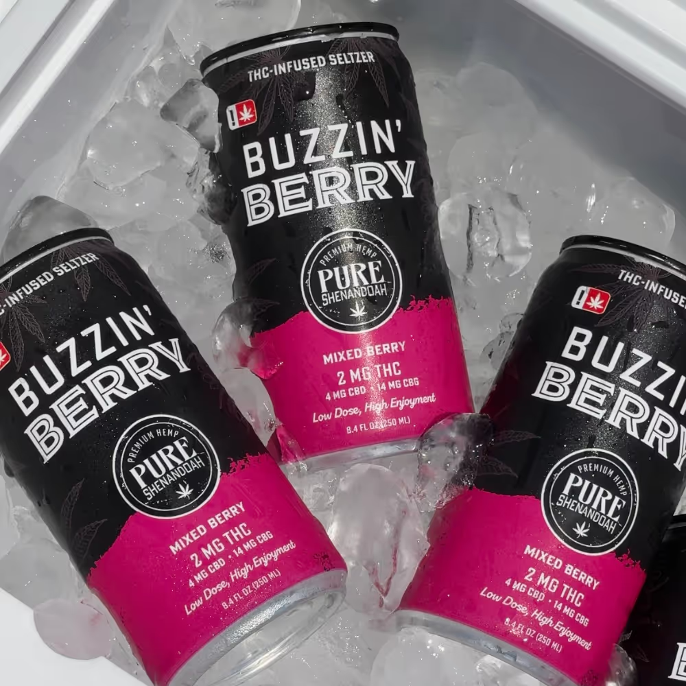 Three Buzzin Berry THC seltzer cans cooling in ice