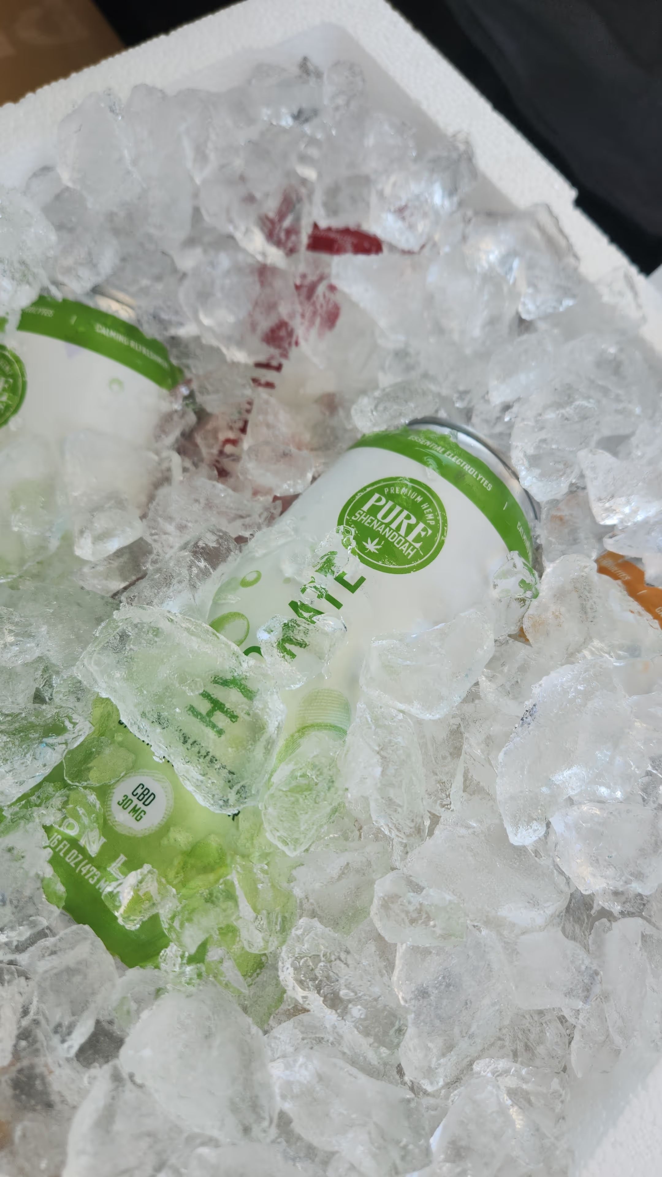 Lemon Lime Hydrate CBD sparkling waters from Pure Shenandoah in a cooler of ice, refreshing Virginia-made hemp beverage.